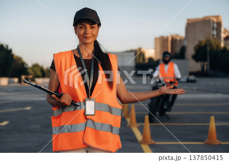 Motorcycle driving license exam. Man and woman are in uniforms Motorcycle driving license exam. Man and woman are in uniforms 137850415