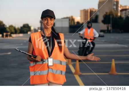 Motorcycle driving license exam. Man and woman are in uniforms Motorcycle driving license exam. Man and woman are in uniforms 137850416