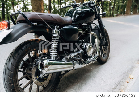 Detailed close up view of black motorcycle that is parked on the road Detailed close up view of black motorcycle that is parked on the road 137850458