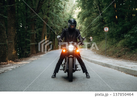 In leather clothes. Man is on motorcycle is on the road In leather clothes. Man is on motorcycle is on the road 137850464