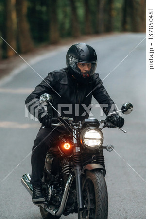 Protective helmet on head, safety first. Man in leather clothes on motorcycle is on the road 137850481