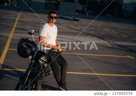 Yellow gloves is in hands. Man is outdoors with his motorcycle Yellow gloves is in hands. Man is outdoors with his motorcycle 137850554