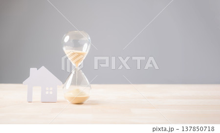 Hourglass time house home mortgage concept shows sand falling, symbolizing property loan payment urgency, representing crucial real estate financial planning and investment decisions Hourglass time house home mortgage concept shows sand falling, symbolizing property loan payment urgency, representing crucial real estate financial planning and investment decisions 137850718