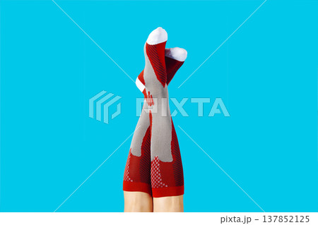 a man lifts his legs wearing red compression socks a man lifts his legs wearing red compression socks 137852125