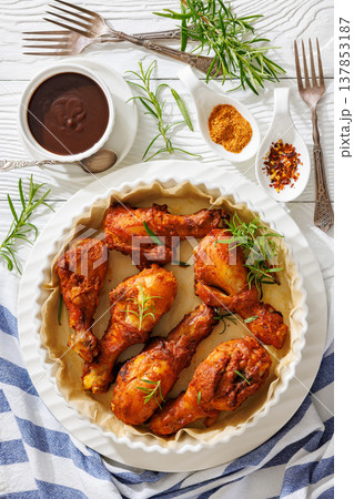 Roasted chicken drumsticks on paper in baking dish 137853187