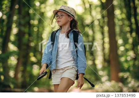 Exploring the nature. Young girl hiker is in the forest 137853490