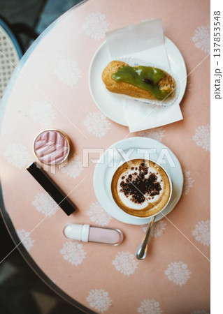 Cappuccino and Pistachio Eclair on Cafe Table Top View 137853548