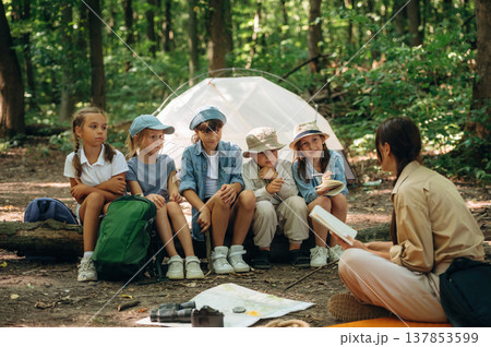 Laughing at story, smiling. Woman is doing tour for group of kids in the forest 137853599