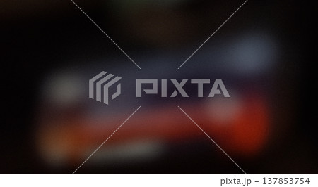 Blurred image of an object with indistinct colors and shapes, featuring a mix of dark and light areas, creating an abstract visual effect 137853754