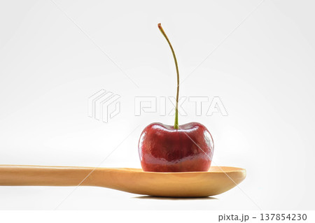 Red cherry on wooden spoon Red cherry on wooden spoon 137854230