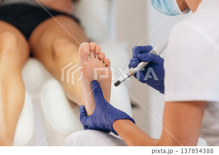 Procedure is in progress. Podiatrist with client in clinic Procedure is in progress. Podiatrist with client in clinic 137854388