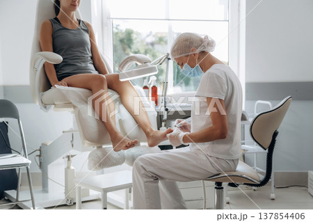 Female podiatrist with woman client in clinic Female podiatrist with woman client in clinic 137854406