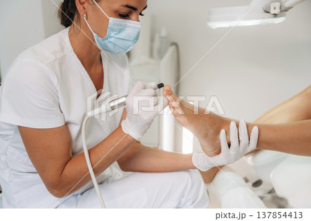Professional care, work in progress. Podiatrist with client in clinic 137854413