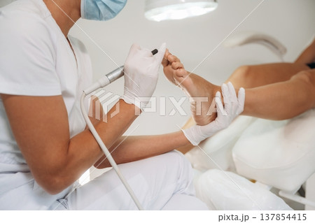 Professional care, work in progress. Podiatrist with client in clinic Professional care, work in progress. Podiatrist with client in clinic 137854415