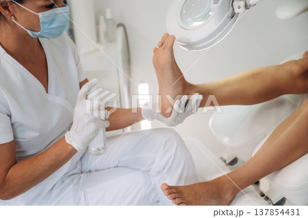 Antiseptic treatment. Podiatrist with client in clinic Antiseptic treatment. Podiatrist with client in clinic 137854431
