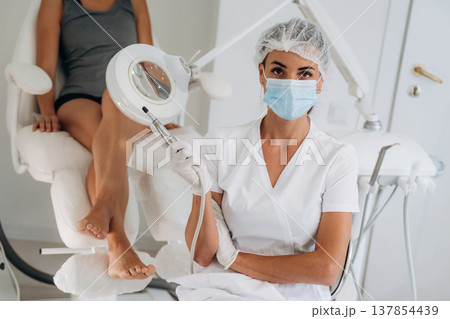 Looking at the camera, sitting. Podiatrist with client in clinic Looking at the camera, sitting. Podiatrist with client in clinic 137854439