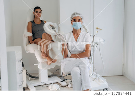 Looking at the camera, sitting. Podiatrist with client in clinic Looking at the camera, sitting. Podiatrist with client in clinic 137854441