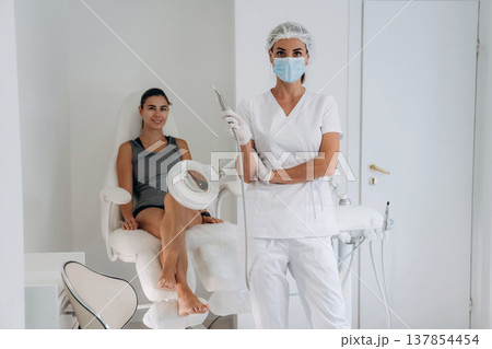 Doctor in mask is standing. Podiatrist with client in clinic 137854454