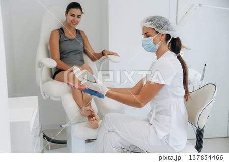 Shape of the feet. Podiatrist with client in clinic 137854466