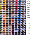 Vertical photo with many thread spools arranged in even rows. Bright image for sewing, tailoring, craft, atelier and textile supply themes. 137855010