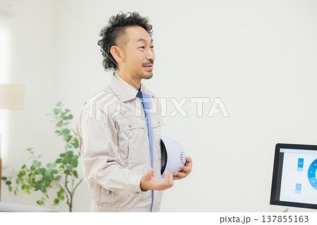 会社で資料を見ながら打ち合わせするエンジニア 会社で資料を見ながら打ち合わせするエンジニア 137855163