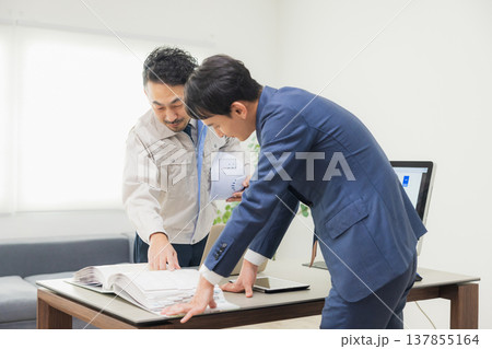 会社で資料を見ながら打ち合わせするエンジニア 会社で資料を見ながら打ち合わせするエンジニア 137855164