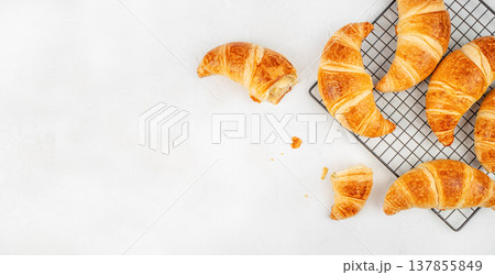 Croissants on Cooling Rack with Bite and Crumbs on White Background Croissants on Cooling Rack with Bite and Crumbs on White Background 137855849