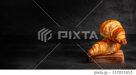 Croissants on Wooden Board over Black Background 137855855