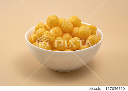 Crunchy cheese corn puff balls snack in white bowl, full depth of field, copy space Crunchy cheese corn puff balls snack in white bowl, full depth of field, copy space 137856560