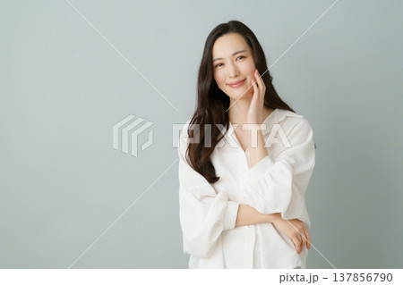 グレーバックの若い白いシャツを着た笑顔の日本人女性のポートレート グレーバックの若い白いシャツを着た笑顔の日本人女性のポートレート 137856790