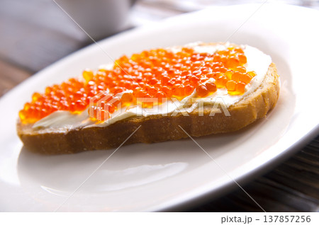 Sandwiches with red caviar, salmon on a slice of bread with cream cheese. Sandwiches with red caviar, salmon on a slice of bread with cream cheese. 137857256