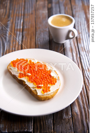 Sandwiches with red caviar, salmon on a slice of bread with cream cheese. 137857257