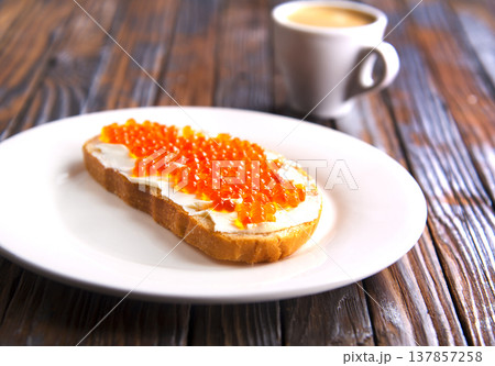 Sandwiches with red caviar, salmon on a slice of bread with cream cheese. Sandwiches with red caviar, salmon on a slice of bread with cream cheese. 137857258
