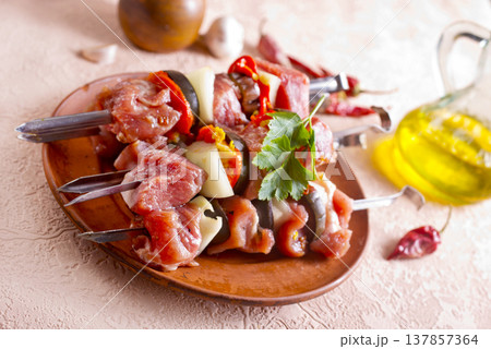 Lamb skewers on light background. Raw lamb skewer with herbs and spices. 137857364