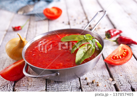 Flat lay composition with delicious tomato cream soup in bowl on white wooden table. Flat lay composition with delicious tomato cream soup in bowl on white wooden table. 137857405