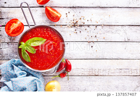 Flat lay composition with delicious tomato cream soup in bowl on white wooden table. 137857407