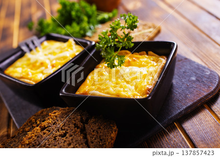 potato with cheese sauce in dark bowl on a table potato with cheese sauce in dark bowl on a table 137857423