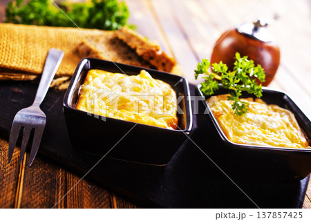 potato with cheese sauce in dark bowl on a table 137857425