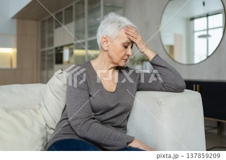 Sad tired ill sick lonely disappointed older senior woman sitting at home alone. Unhappy mature grandmother experiencing grief relative death bad news. Stressed elder lady suffering from loneliness 137859209