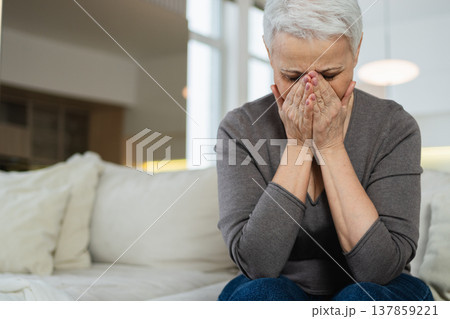 Sad tired ill sick lonely disappointed older senior woman sitting at home alone. Unhappy mature grandmother experiencing grief relative death bad news. Stressed elder lady suffering from loneliness Sad tired ill sick lonely disappointed older senior woman sitting at home alone. Unhappy mature grandmother experiencing grief relative death bad news. Stressed elder lady suffering from loneliness 137859221