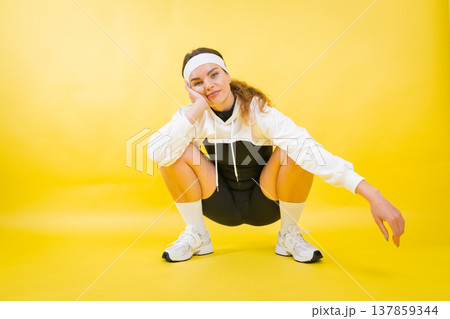 Young woman squatting in trendy sporty athletic wear 137859344