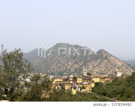 Wide scenic view of Amber Fort nestled at the foot of the Aravalli hills near Jaipur. Historic 137859492