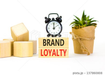 Brand loyalty words symbol. Concept words Brand loyalty on beautiful wooden blocks. Beautiful white background. Black alarm clock. Business and Brand loyalty words concept. Copy space. 137860808