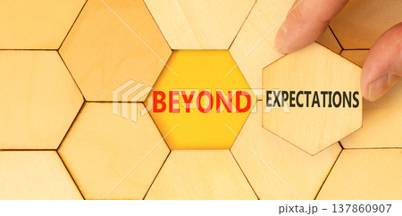 Beyond expectations words symbol. Concept words Beyond expectations on beautiful wooden puzzles. Beautiful yellow background. Businessman hand. Business Beyond expectations words concept. Copy space. 137860907