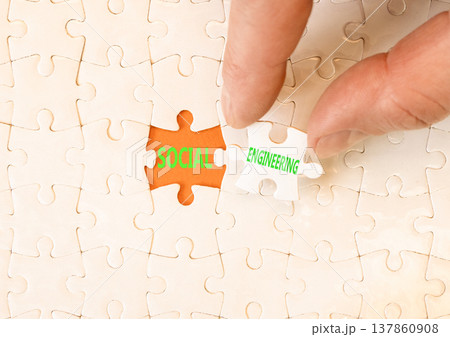 Social engineering words symbol. Concept words Social engineering on beautiful white puzzles. Beautiful orange background. Businessman hand. Business and Social engineering words concept. Copy space. 137860908