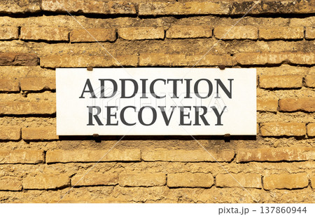 Addiction recovery symbol. Concept words Addiction recovery on beautiful big white sign plate. Beautiful old brown brick wall background. Psychology addiction recovery concept. Copy space. Addiction recovery symbol. Concept words Addiction recovery on beautiful big white sign plate. Beautiful old brown brick wall background. Psychology addiction recovery concept. Copy space. 137860944