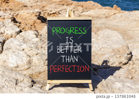 Progress or perfection words symbol. Concept words Progress is better than perfection on beautiful black blackboard. Beautiful stone background. Business progress or perfection concept. Copy space. 137861048