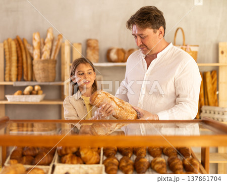 Father and little daughter choosing fresh bread from bakery display Father and little daughter choosing fresh bread from bakery display 137861704