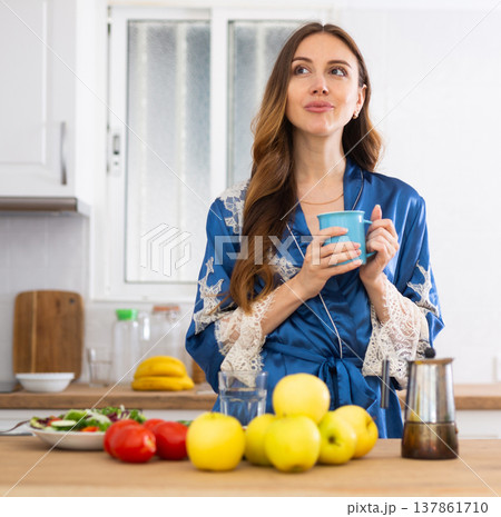 Positive woman having breakfast, drinking coffee Positive woman having breakfast, drinking coffee 137861710