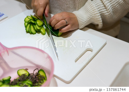 きゅうりを輪切りにする主婦 137861744
